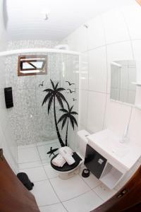 a bathroom with a palm tree stenciled on the wall at Espaço Vintage in Piçarras