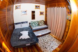 a small bedroom with a bed and a couch at Espaço Vintage in Piçarras