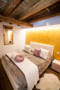 een slaapkamer met een groot bed met kussens erop bij The Key Of Bergamo in Bergamo