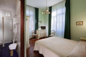 a bedroom with a bed and a dresser and a mirror at Hotel Savona in Montecatini Terme
