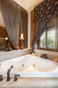 a large white tub in a bathroom with a window at The Londonderry Inn in Hershey