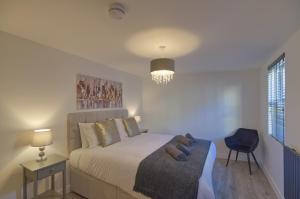 a bedroom with a bed and a chair and a window at Marina Walk, New Luxury Coastal Apartment in The English Riviera, close to the Shops, Bars and Restaurants with Torquay Marina and Torre Abbey Sands Beach a short walk away! in Torquay