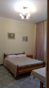 a bedroom with a bed and a chandelier at Sonce - Tirana in Tirana