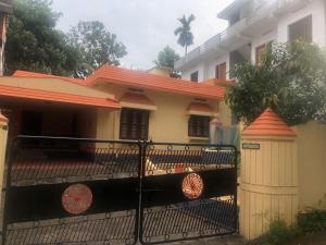 uma casa com uma cerca de ferro em frente em Konni Town Central House with AC rooms em Koni