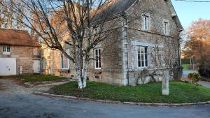 an old brick building with a tree in front of it at Les Mancelles in Condé-sur-Sarthe