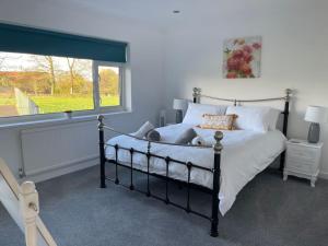 a bedroom with a black and white bed and a window at Luxury Home nestled in the South downs countryside in Bramber