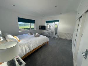 a bedroom with a large bed and a window at Luxury Home nestled in the South downs countryside in Bramber