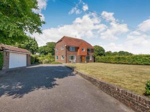 a brick house with a driveway in front of a yard at Luxury Home nestled in the South downs countryside in Bramber