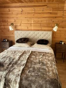 a large bed in a room with wooden walls at Le Chalet d’Andrea in Vars