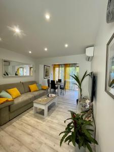 a living room with a couch and a table at A1 LA PLAGE D'OR in Le Lavandou