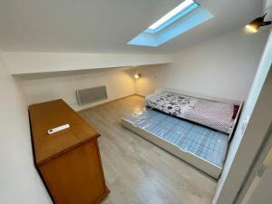 Cette petite chambre comprend un lit et une table. dans l'établissement Au calme, maison T3 neuf avec Jardin à Cassy, à Lanton