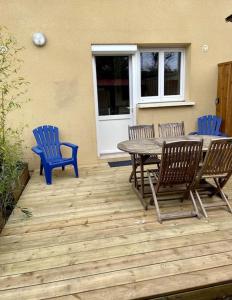 d'une terrasse avec une table, 3 chaises et une table. dans l'établissement Au calme, maison T3 neuf avec Jardin à Cassy, à Lanton