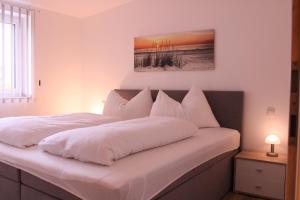 - une chambre avec 2 lits et des oreillers blancs dans l'établissement Appartement Seeleben, à Bodensdorf