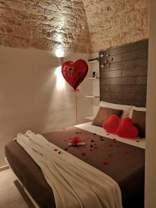 a bedroom with a bed with a red heart balloon at Suite Mazzini con piscina in Ostuni
