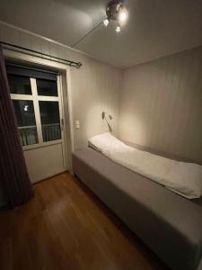 a small bedroom with a bed and a window at Skjomtind - Modern apartment with free parking in Narvik