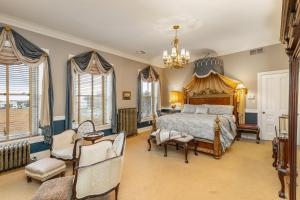a bedroom with a bed and chairs and a chandelier at The Londonderry Inn in Hershey