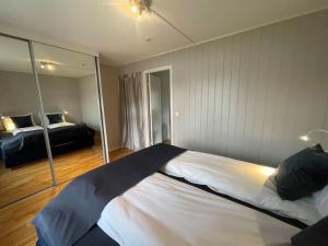 a bedroom with a large bed and a mirror at Skjomtind - Modern apartment with free parking in Narvik