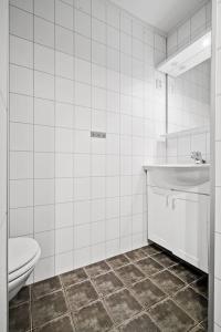 a white bathroom with a toilet and a sink at Skjomtind - Modern apartment with free parking in Narvik