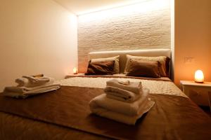 una camera da letto con un letto e asciugamani di CentroCittà Suite a Catania