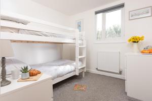 a bedroom with two bunk beds and a window at Wheal Amelia- Beautifully Fitted Wooden Lodge Helston Cornwall in Helston