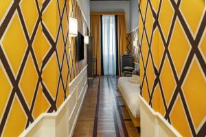 ein Hotelzimmer mit gelben Wänden und einem Sofa in der Unterkunft Il Campo Marzio in Rom