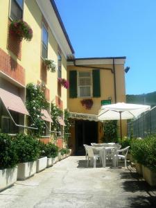 a table and chairs with an umbrella in front of a building at Hotel Lea in Grosseto