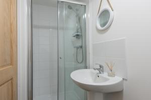 a bathroom with a sink and a glass shower at Wheal Amelia- Beautifully Fitted Wooden Lodge Helston Cornwall in Helston +11 photos
