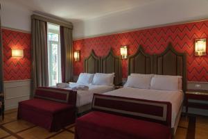 een hotelkamer met 2 bedden en een rode muur bij Il Campo Marzio in Rome