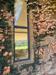 una finestra in un muro di mattoni con fiori rosa di Preciosa casa unifamiliar en calella a Calella de Palafrugell