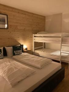 ビヒルバッハにあるAlpenhaus Bichlbachの木製の壁の客室で、二段ベッド2組が備わります。