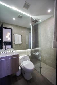 a bathroom with a toilet and a sink and a shower at AmazINN Places Rooftop and Design Pool III in Panama City