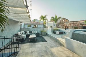 un patio con sofá y mesa en un edificio en AmazINN Places Rooftop and Design Pool III en Panamá