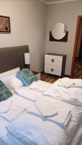 two white beds in a bedroom with a dresser at Apartament Podgórze 13 in Szklarska Poręba