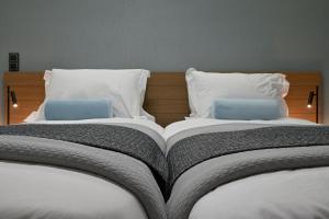 A bed or beds in a room at The Lop Athens Holidays Luxury Suites