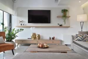 A television and/or entertainment centre at The Lop Athens Holidays Luxury Suites