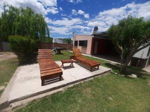 un grupo de bancos sentados en un patio en Cabañas Lujan en El Volcán