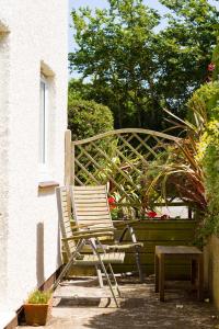 a rocking chair and a bench on a patio at Gwithian Holidays in Hayle