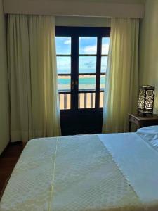 a bedroom with a bed with a view of the ocean at Casa Rio - 04 Quartos de Frente para o Mar in Guarda do Embaú
