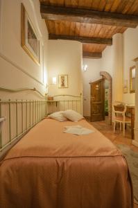 ein Schlafzimmer mit einem Bett mit einer orangefarbenen Decke in der Unterkunft Mondo Antico B&B in Cesena