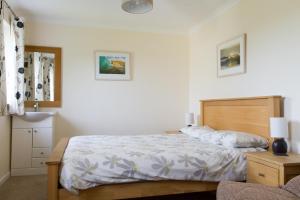 a bedroom with a large bed and a chair at Gwithian Holidays in Hayle
