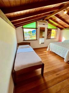 a bedroom with two beds and a large window at Casa Rio - 04 Quartos de Frente para o Mar in Guarda do Embaú