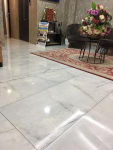 a white marble floor in a lobby with a table and flowers at Vizyon Hotel in Istanbul