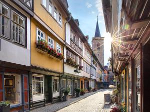 eine schmale Straße mit Gebäuden und einer Kirche im Hintergrund in der Unterkunft Schöne helle Ferienwohnung 64qm mit Kingsize Bett, Smart-TV, Wlan und sehr ruhige Lage in Erfurt