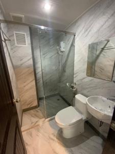 y baño con ducha, aseo y lavamanos. en Baan Thanakul Residences, en Samutprakarn