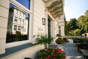 ein Gebäude mit einer Terrasse mit Blumen und einem Fenster in der Unterkunft Villa Usedom in Heringsdorf