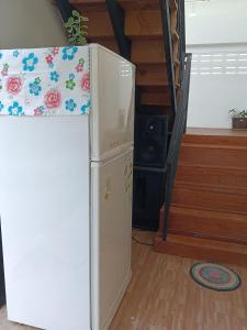 a small refrigerator in a room with a bed at ไร่ดง โฮมเสตย์ in Ban Pong Nua
