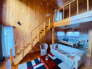 uma sala de estar com uma escada e um sofá em Cabañas Pacífico - Faro Corona em Ancud