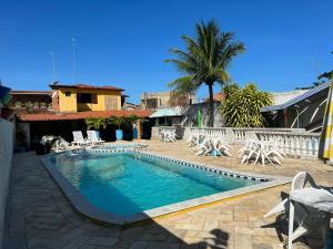 a swimming pool with chairs and a resort at Pousada Don Robledo in São Miguel dos Milagres