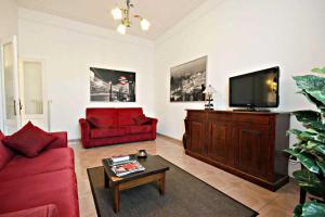 een woonkamer met een rode bank en een flatscreen-tv bij Appartamento Lucas in Rome