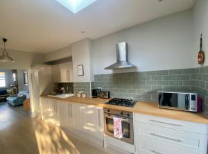 a kitchen with a stove and a microwave at Delightful 2 Bedroom House Central Windsor in Windsor
